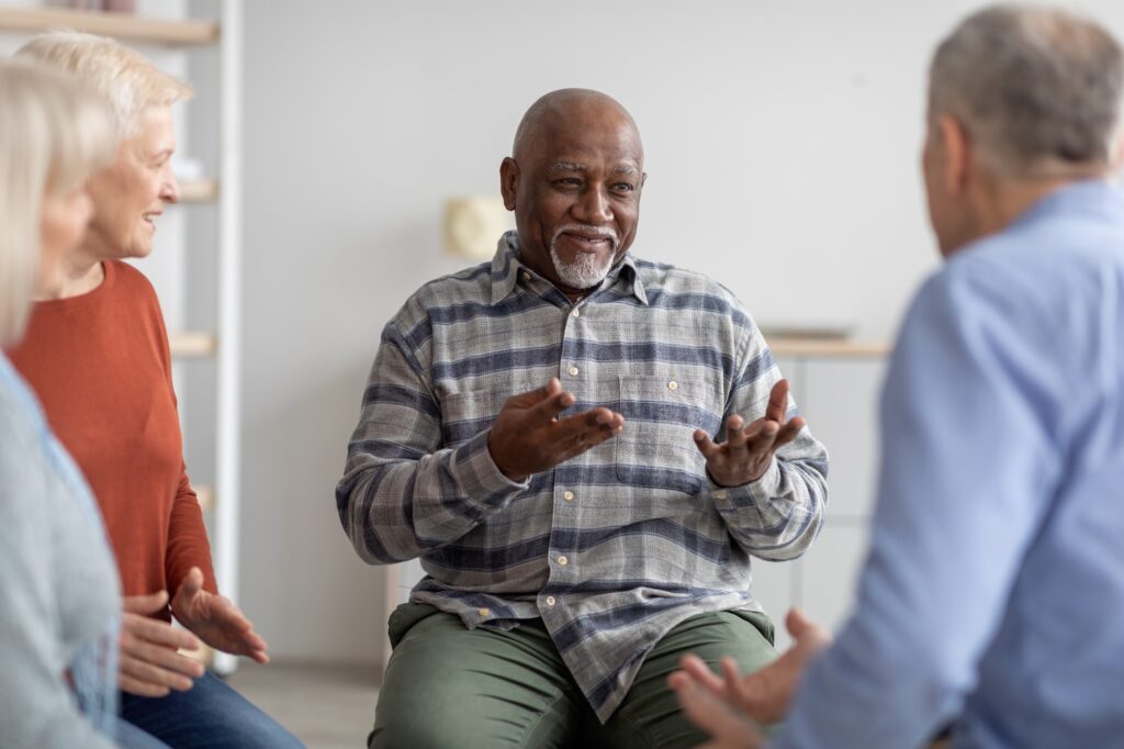 Cheerful african american elderly man having conversation with coach